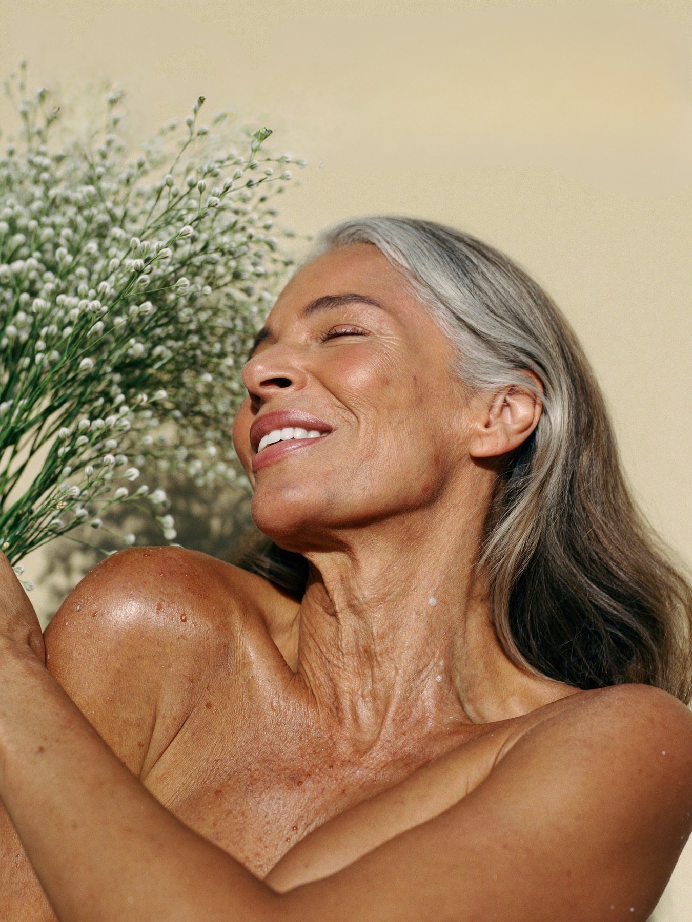 Donna serena e luminosa che sorride con fiori, luce naturale calda